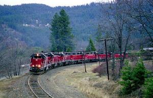 Seven engines in front of a freight train, climbing.