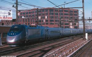 Acela Express in front of a brick building